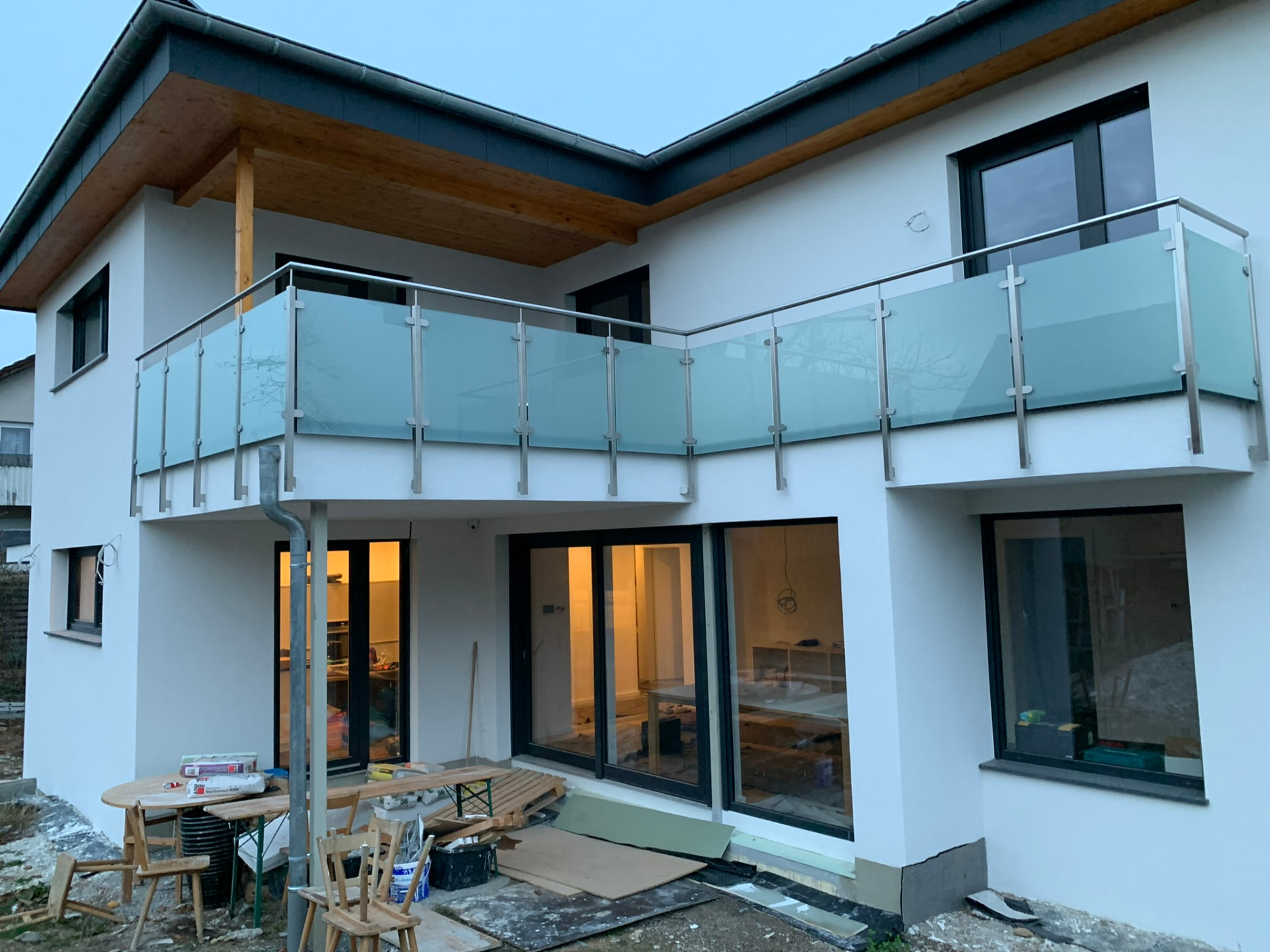 Balkongeländer mit satiniertem Glas und Edelstahlpfosten an einem Neubau